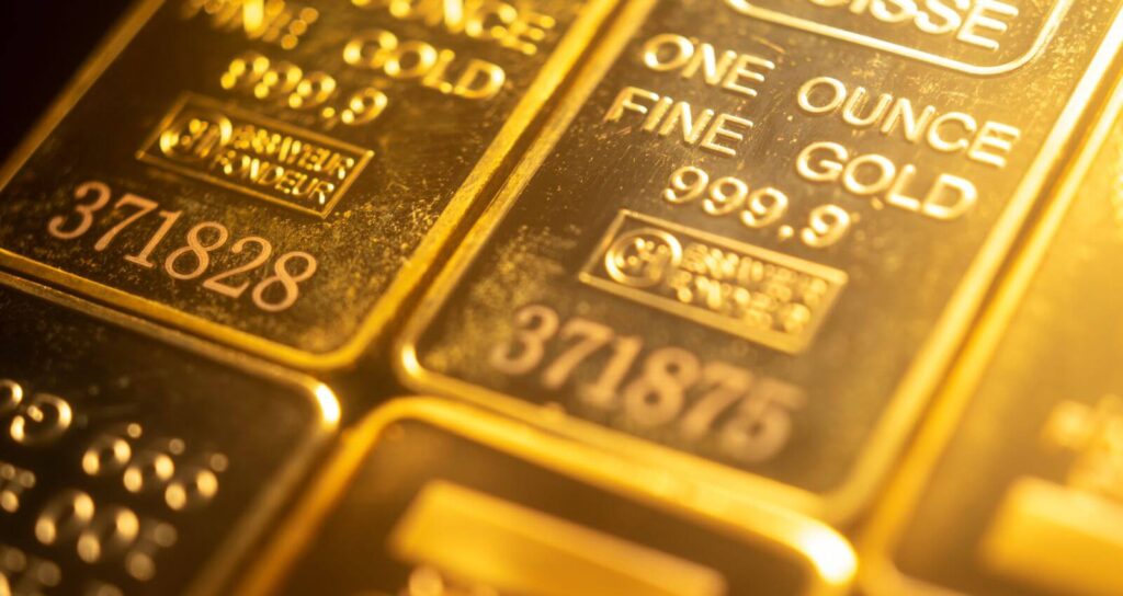 Close-up of two 1 oz fine gold bars stamped 999.9 purity with unique serial numbers.